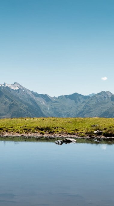 Bergpanorama der Hohen Tauern hinter einer Wetterlacke bei Piesendorf. | © Ferienregion Nationalpark Hohe Tauern - Mathäus Gartner