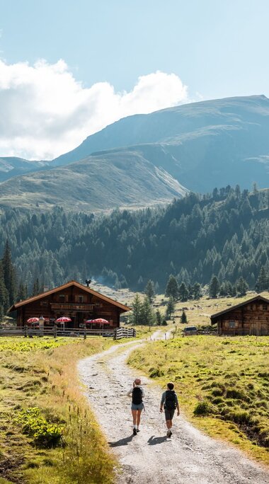 Zwei Wanderer am Schild „Nationalpark Hohe Tauern – Außenzone“. | © Ferienregion Nationalpark Hohe Tauern / Mathäus Gartner