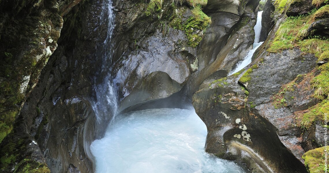 Stunning waterfall flows through a moss-covered rocky gorge surrounded by wild nature. | © Holiday Region National Park Hohe Tauern