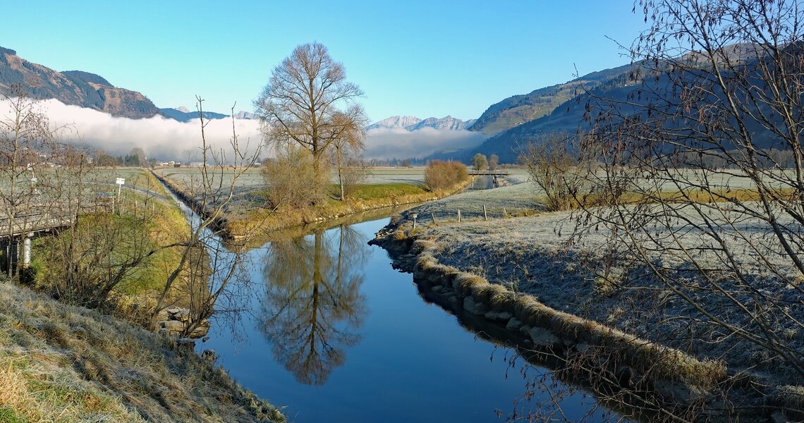 Ein ruhiger Fluss in einer frostigen Morgenlandschaft mit Bergen im Hintergrund. | © BRUCK FUSCH I GROSSGLOCKNER - Bernhard Gritsch 