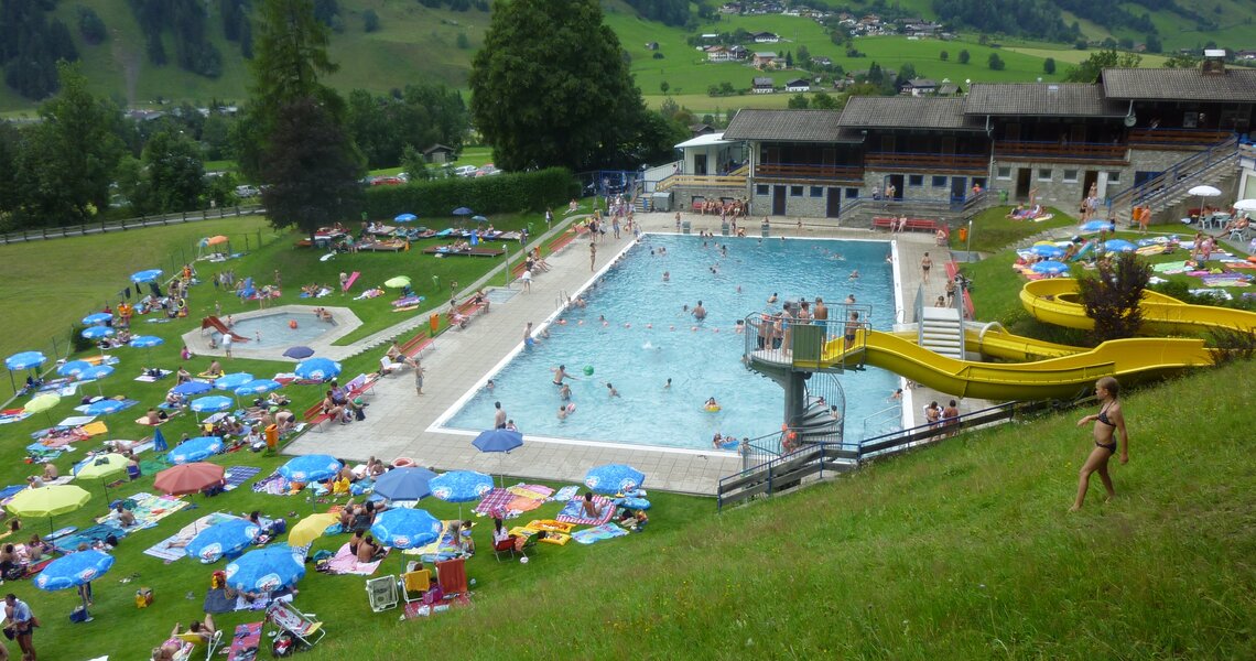 Swimming pool with slide and green mountain panorama at Sonnblickbad Rauris. | © Sonnblickbad Rauris