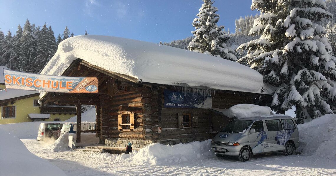 Skischule in Holzhaus mit tief verschneitem Dach. | © (c) Stefans Skischule