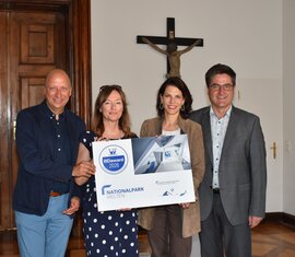 Four people present the IIID Award 2026 for the National Park Worlds. | © FNPHT