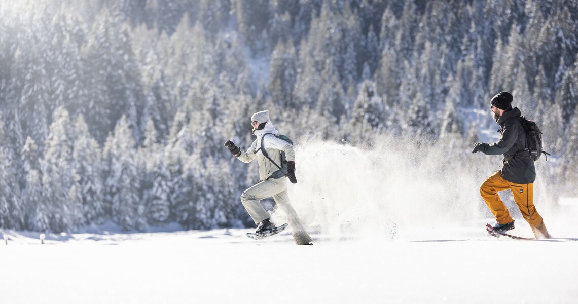 Zwei Personen rennen mit Schneeschuhen durch tiefen Schnee. | © Ferienregion Nationalpark Hohe Tauern - Daniel Breuer